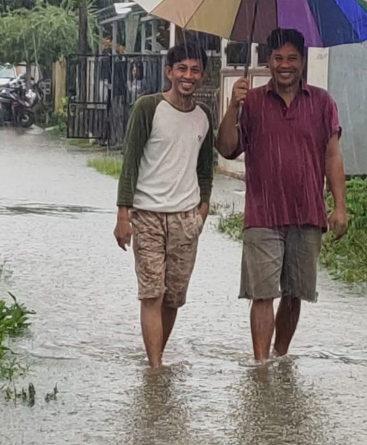 Warga Jl Biola Perumnas Manggala Permai Makassar berjalan di genangan banjir, Minggu (20/12/2020)
